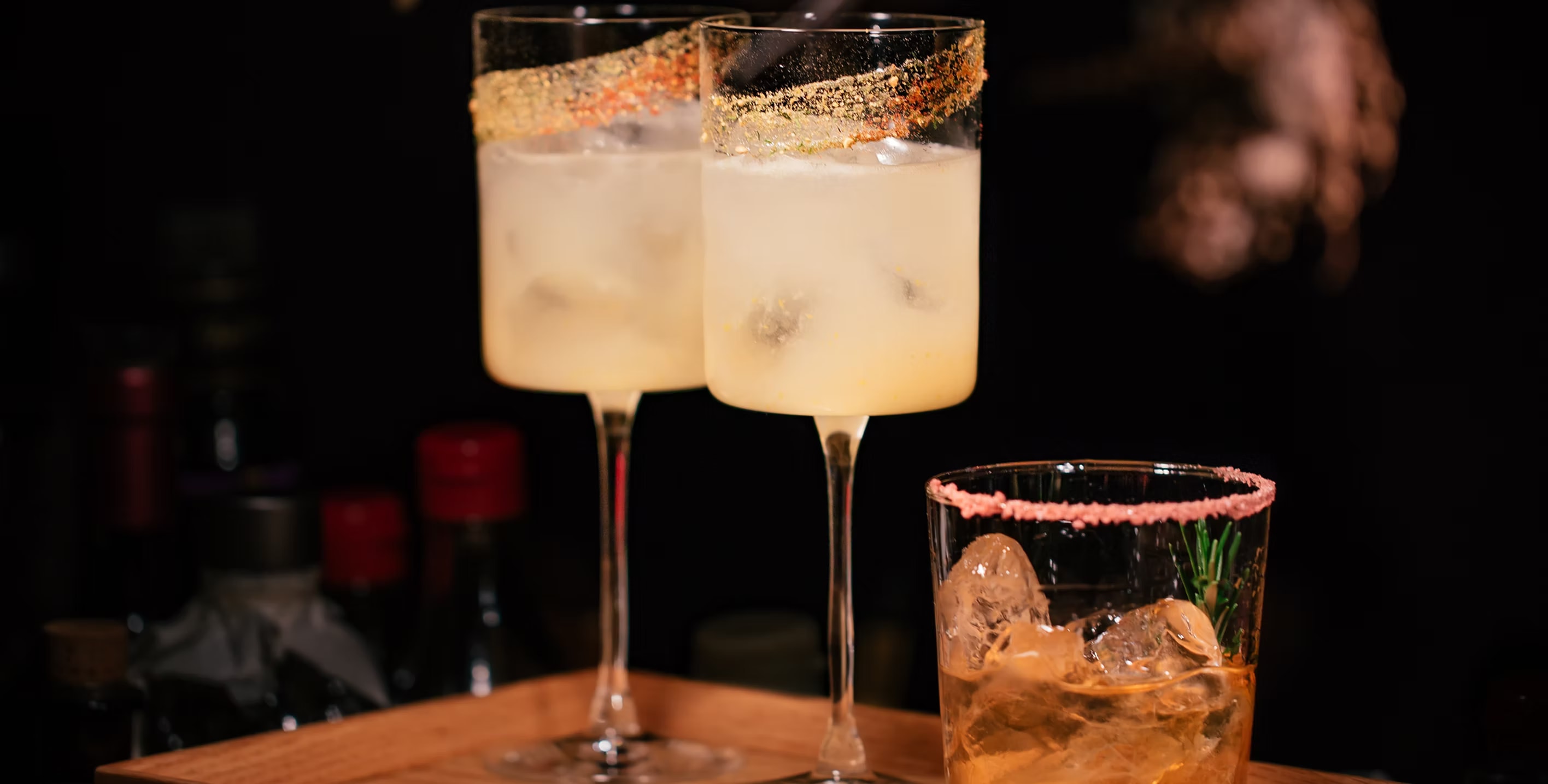 Pao Craft Cocktails champagne flutes with gold rim and whiskey on the rocks