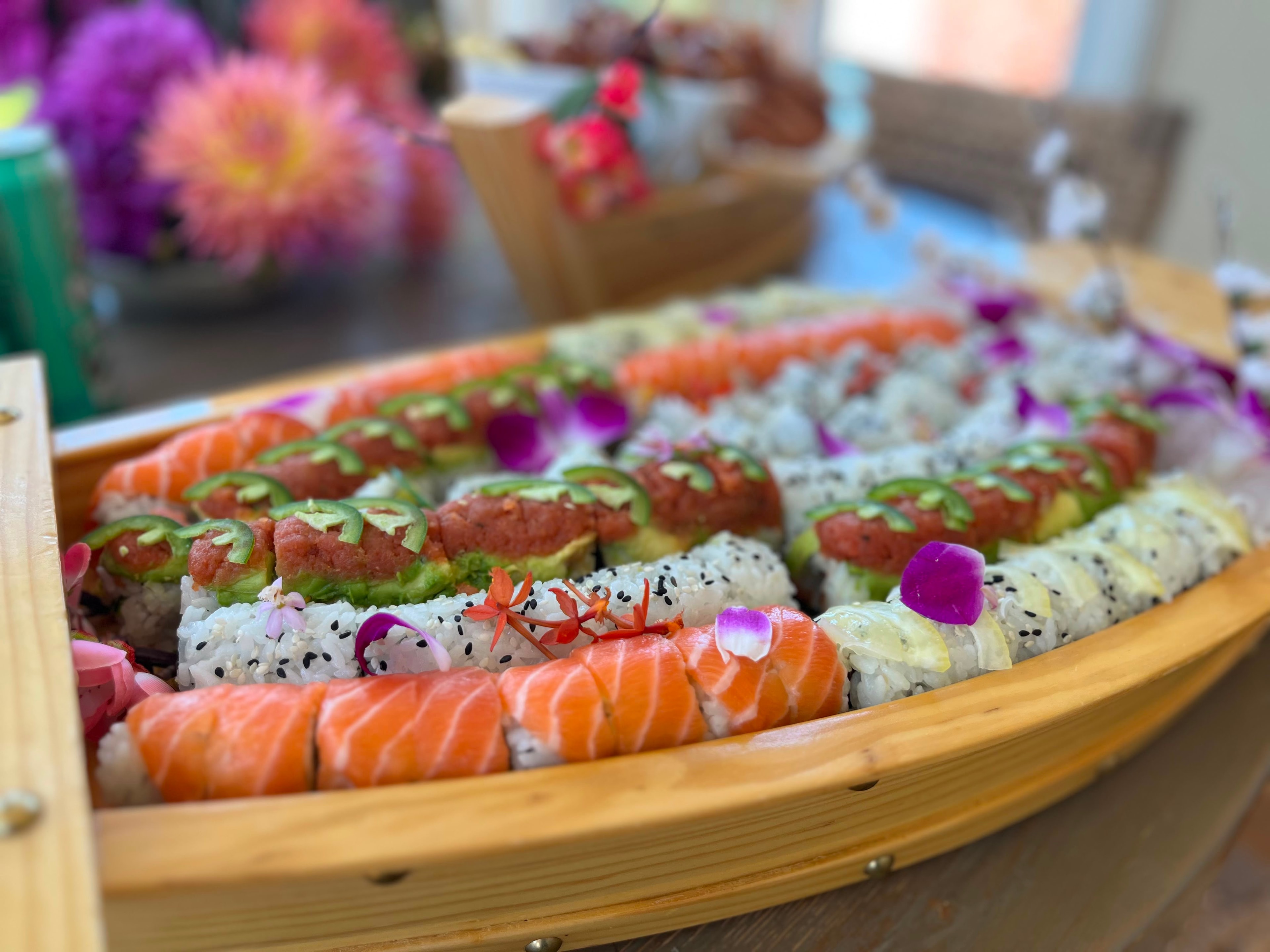 Sushi Boat colorful sushi rolls with edible flowers in a wooden boat